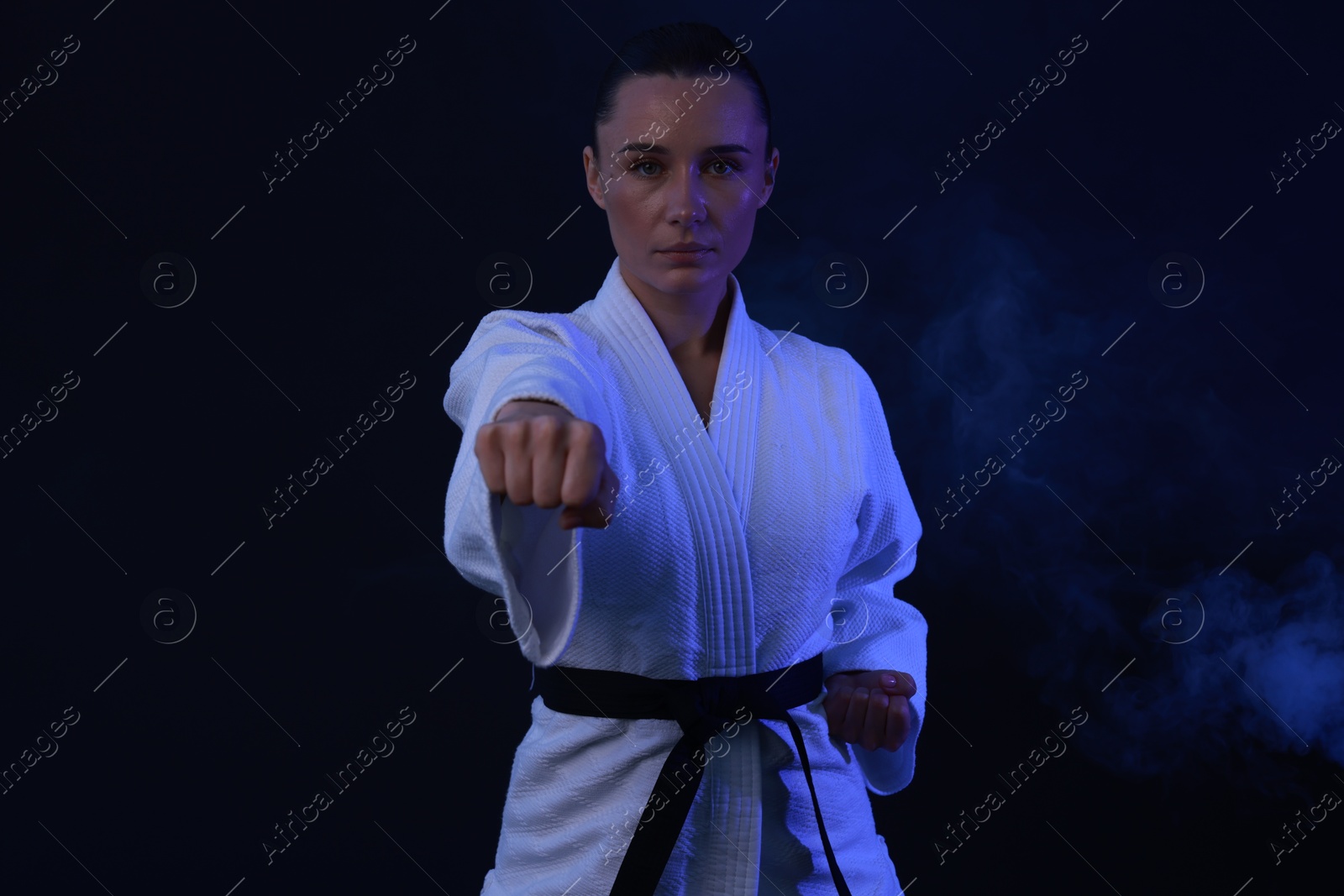 Photo of Karate fighter in kimono on dark background