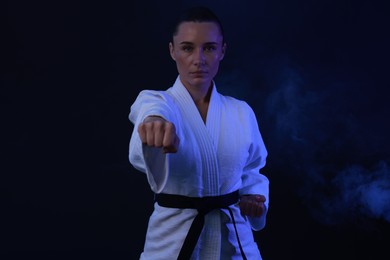 Photo of Karate fighter in kimono on dark background