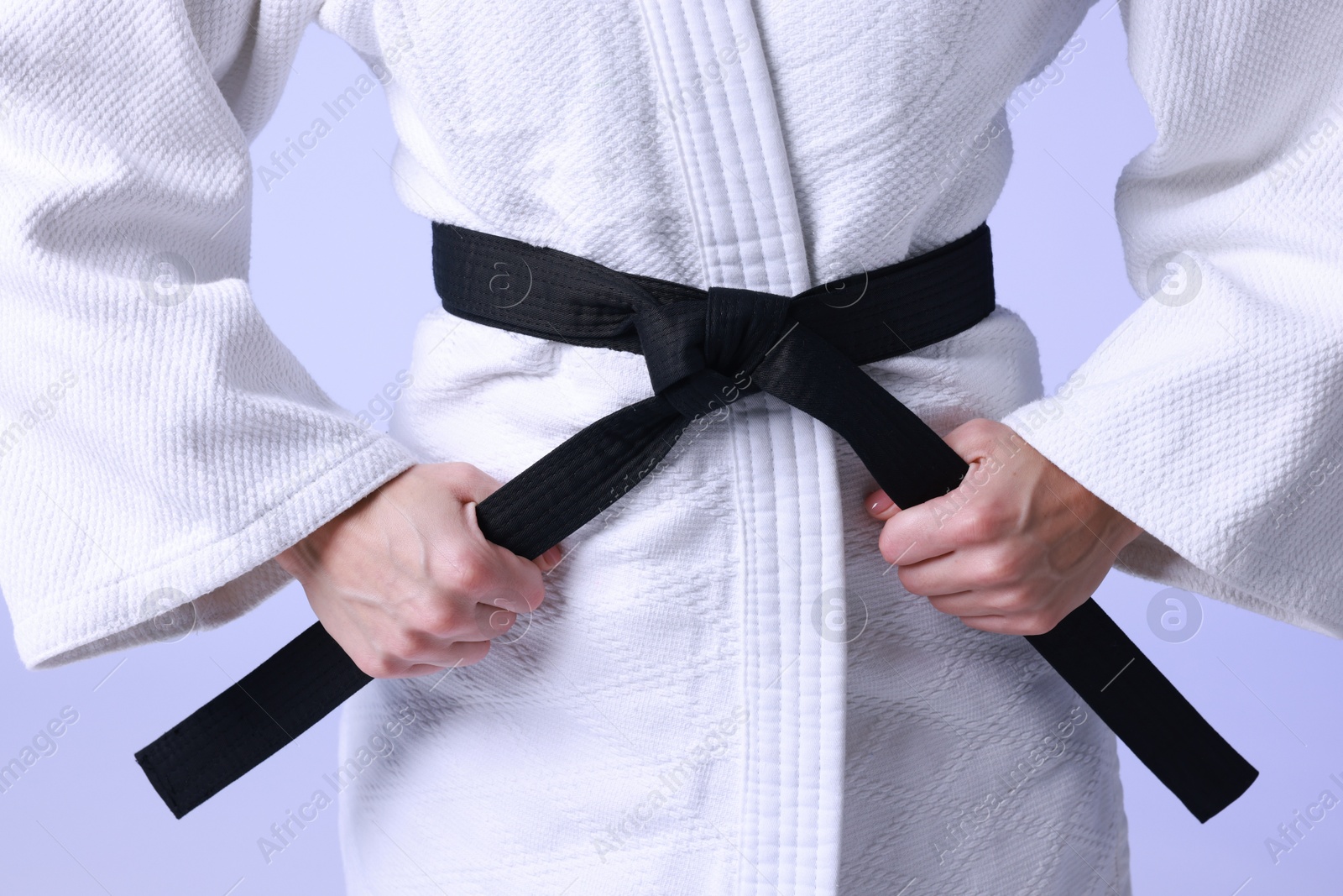 Photo of Karate fighter in kimono on light background, closeup