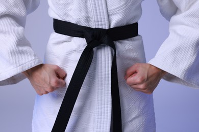 Photo of Karate fighter in kimono on light background, closeup