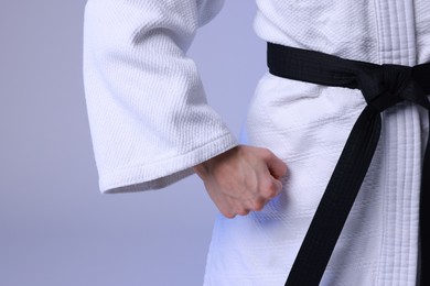 Photo of Karate fighter in kimono on light background, closeup