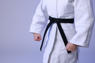 Photo of Karate fighter in kimono on light background, closeup