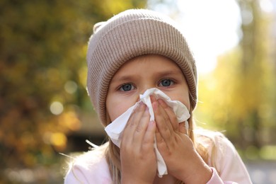 Photo of Little girl with runny nose in park