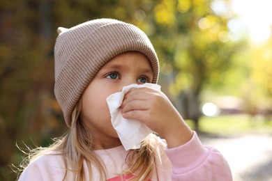 Photo of Little girl with runny nose in park