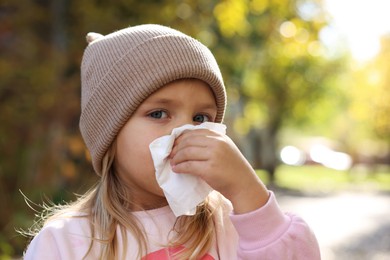 Photo of Little girl with runny nose in park