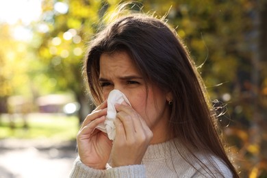 Photo of Young woman with runny nose in park