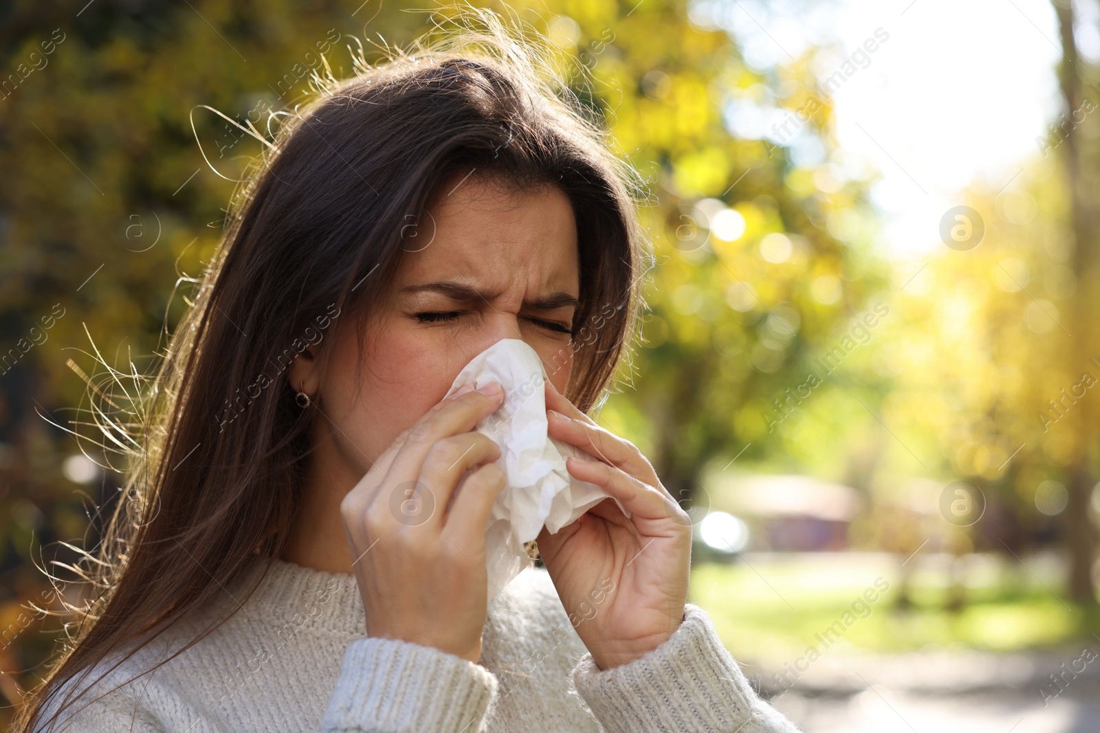 Photo of Young woman with runny nose in park