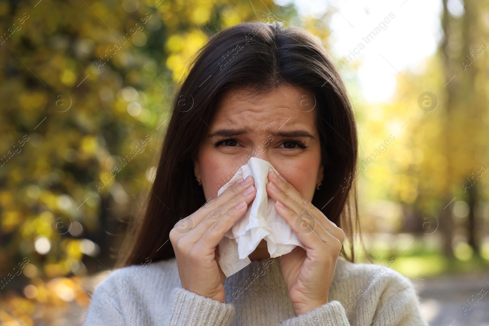 Photo of Young woman with runny nose in park