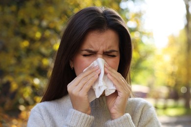 Photo of Young woman with runny nose in park