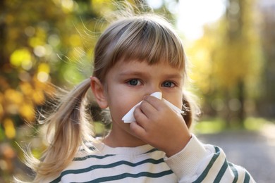 Photo of Little girl with runny nose in park