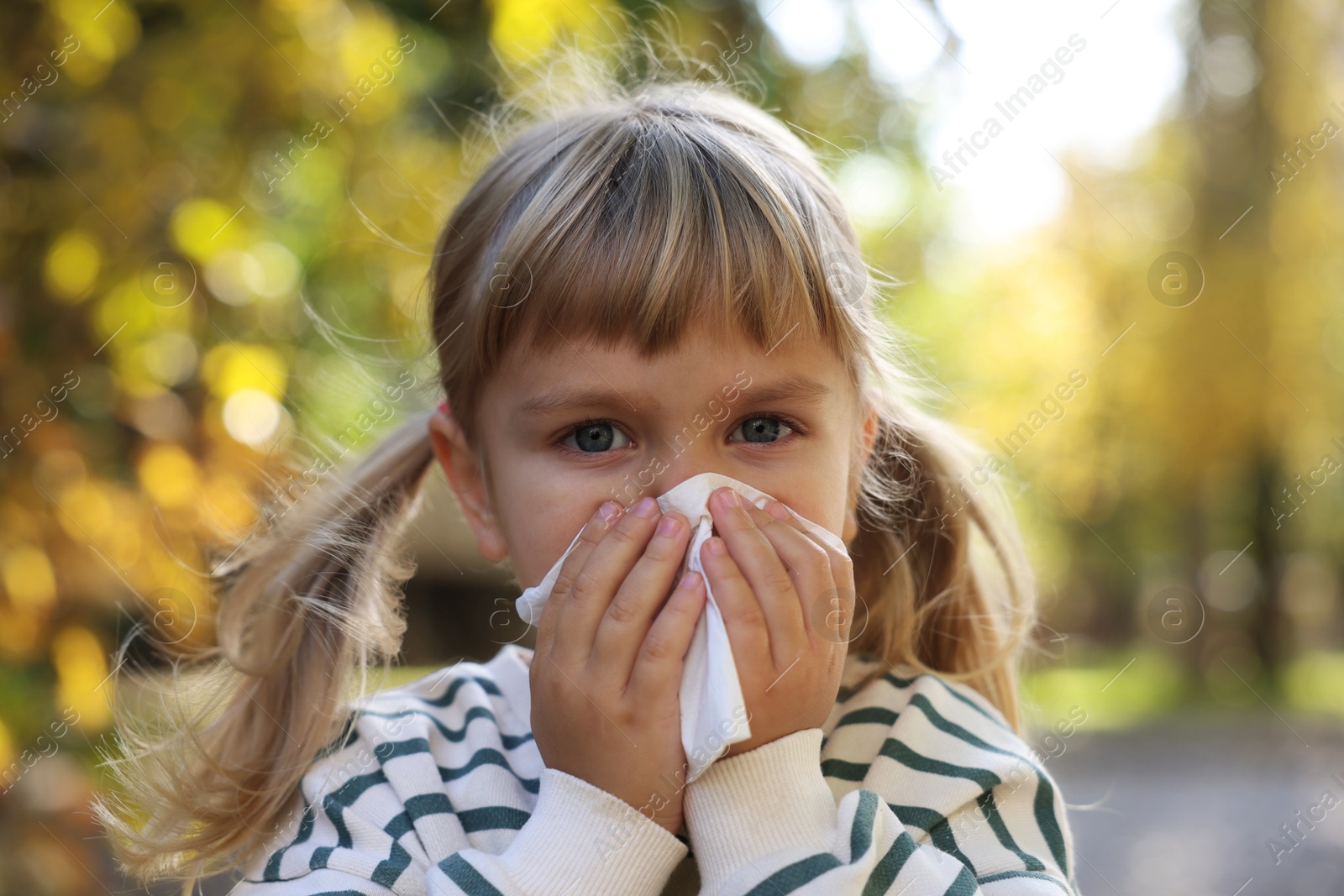 Photo of Little girl with runny nose in park