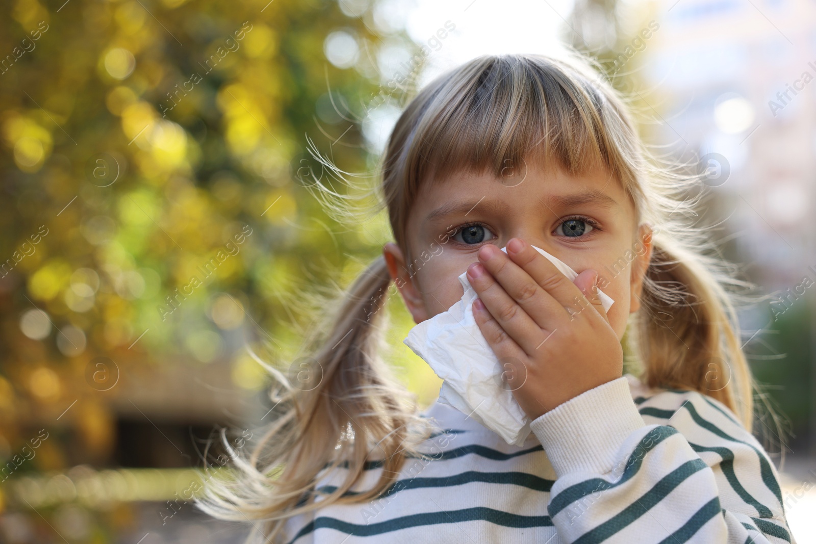 Photo of Little girl with runny nose in park