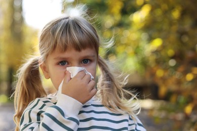 Photo of Little girl with runny nose in park