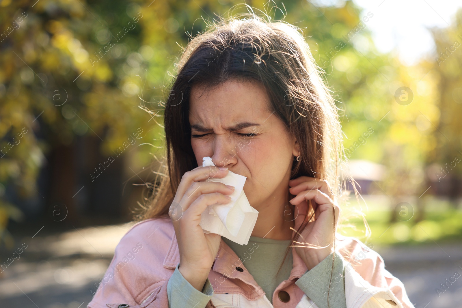 Photo of Young woman with runny nose in park