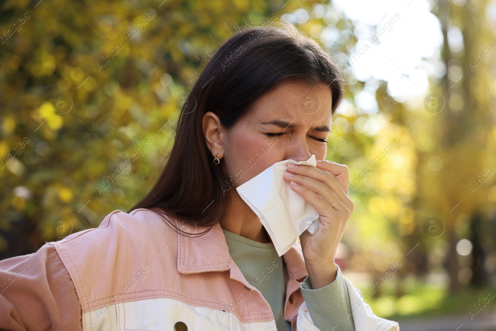 Photo of Young woman with runny nose in park