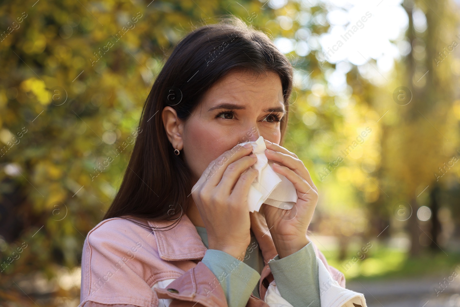 Photo of Young woman with runny nose in park