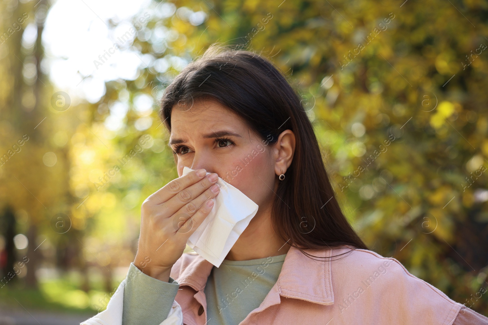 Photo of Young woman with runny nose in park