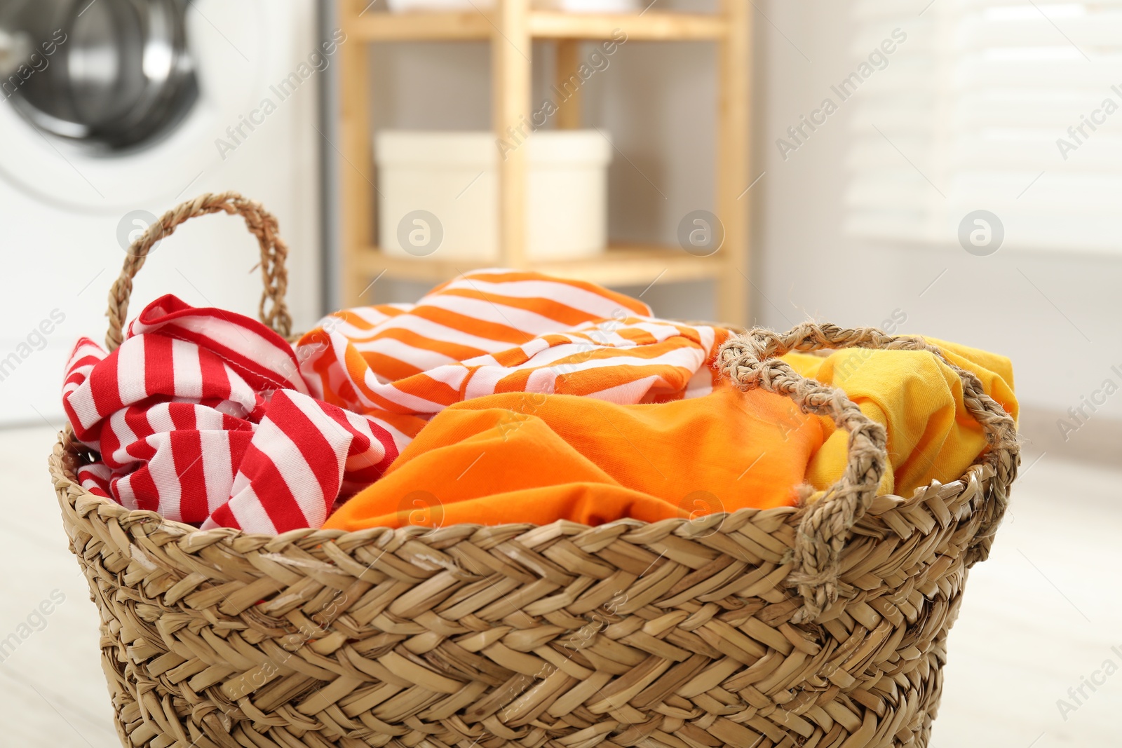 Photo of Wicker basket full of laundry in bathroom, closeup