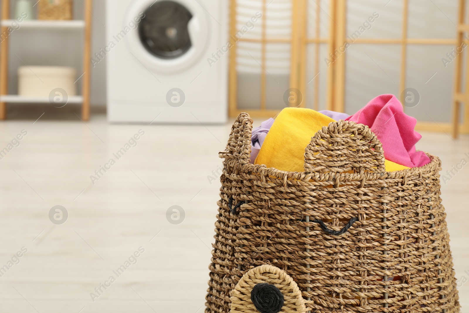 Photo of Wicker basket full of laundry in bathroom, closeup. Space for text