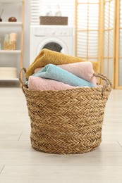 Photo of Wicker basket full of laundry in bathroom