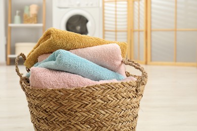 Photo of Wicker basket full of laundry in bathroom, closeup