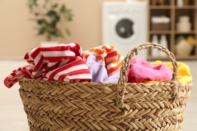 Photo of Wicker basket full of laundry in bathroom, closeup