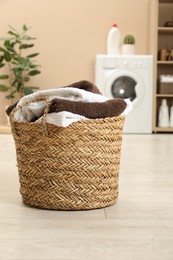 Photo of Wicker basket full of laundry in bathroom