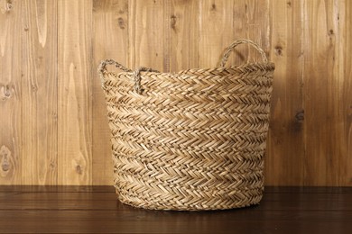 Photo of One wicker laundry basket on wooden table