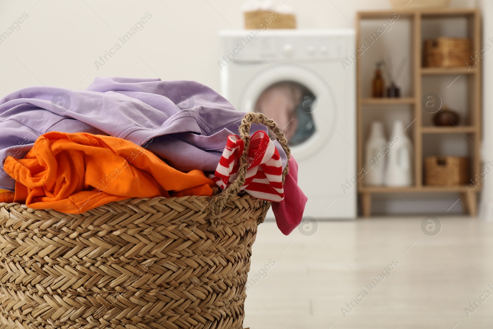 Photo of Wicker basket full of laundry in bathroom, closeup