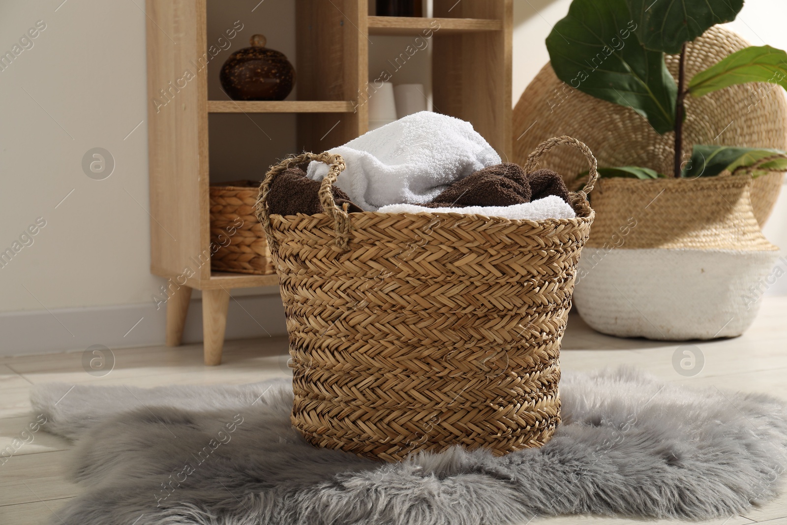 Photo of Wicker basket full of laundry in bathroom