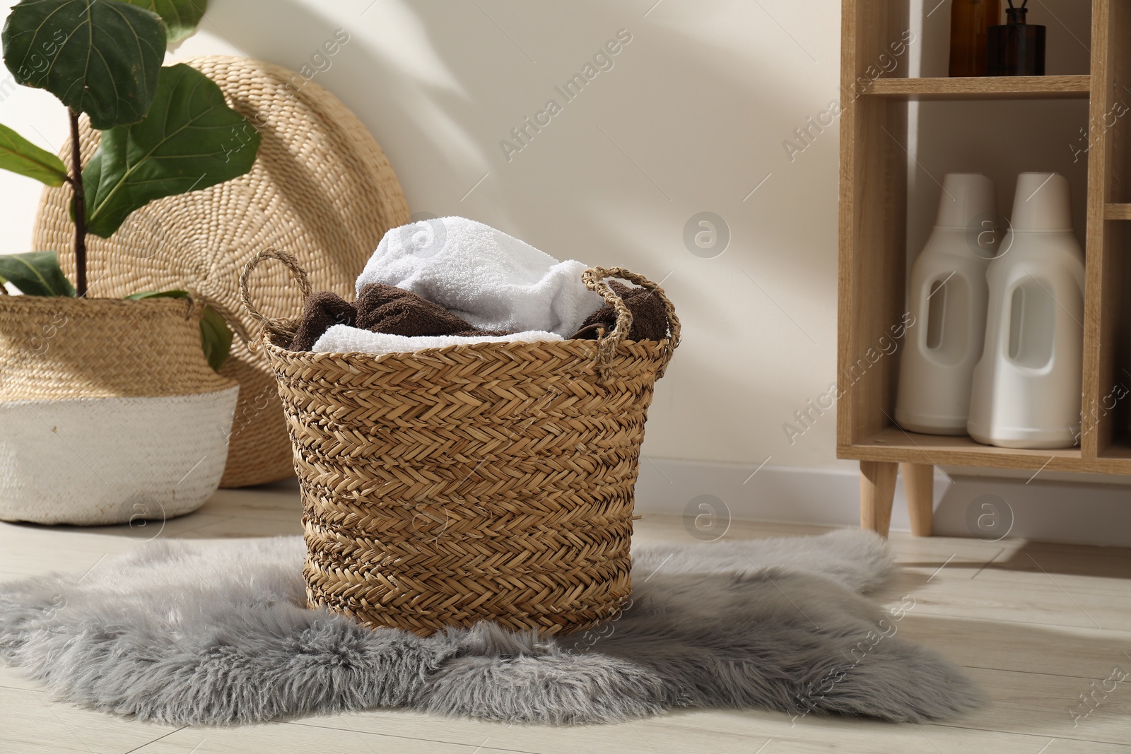 Photo of Wicker basket full of laundry in bathroom