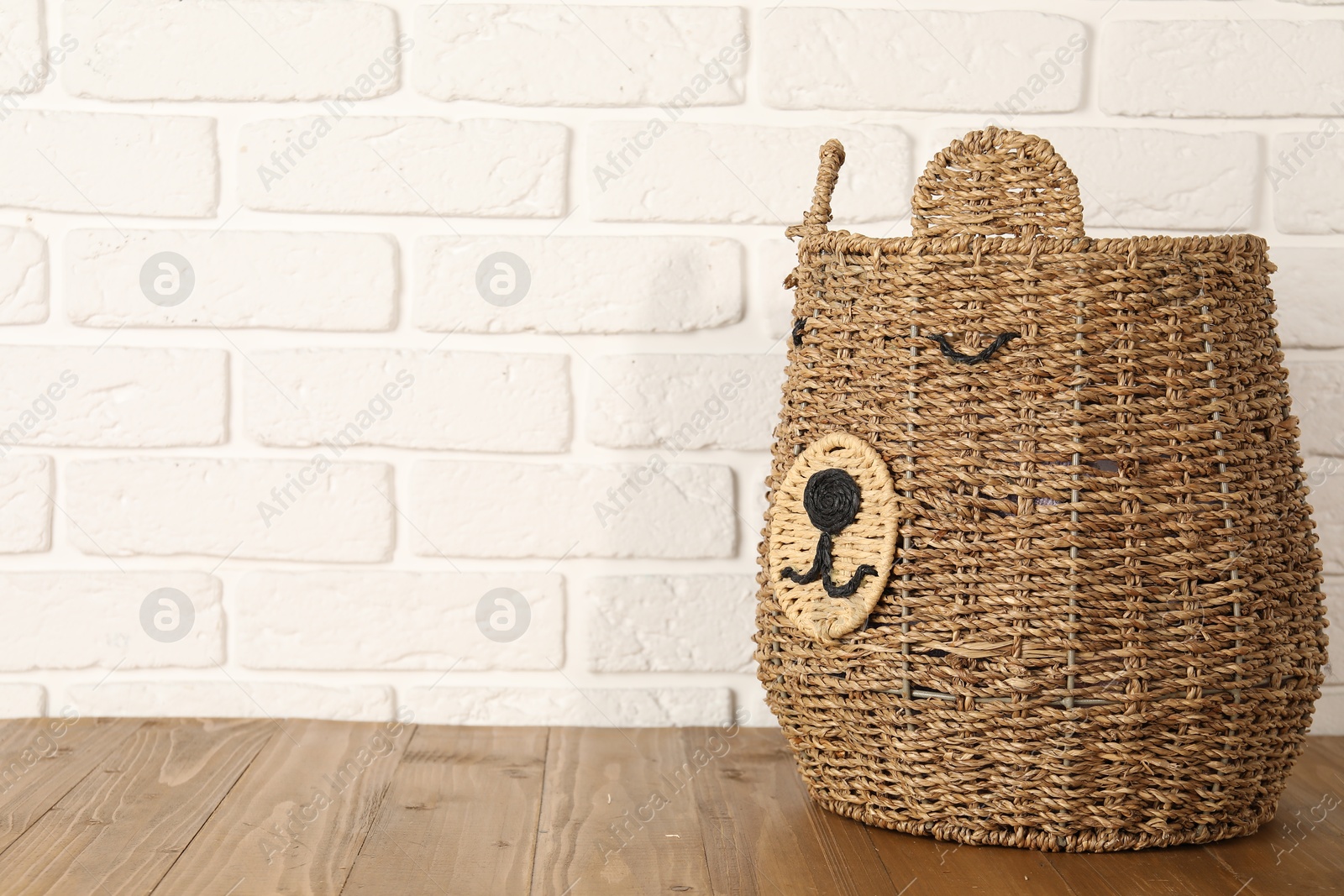 Photo of One wicker laundry basket on wooden table, space for text