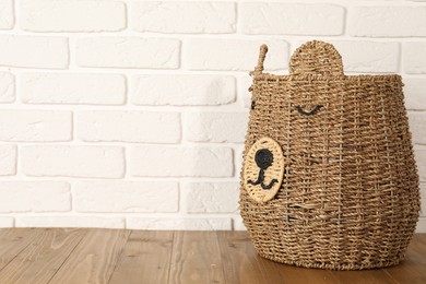 Photo of One wicker laundry basket on wooden table, space for text