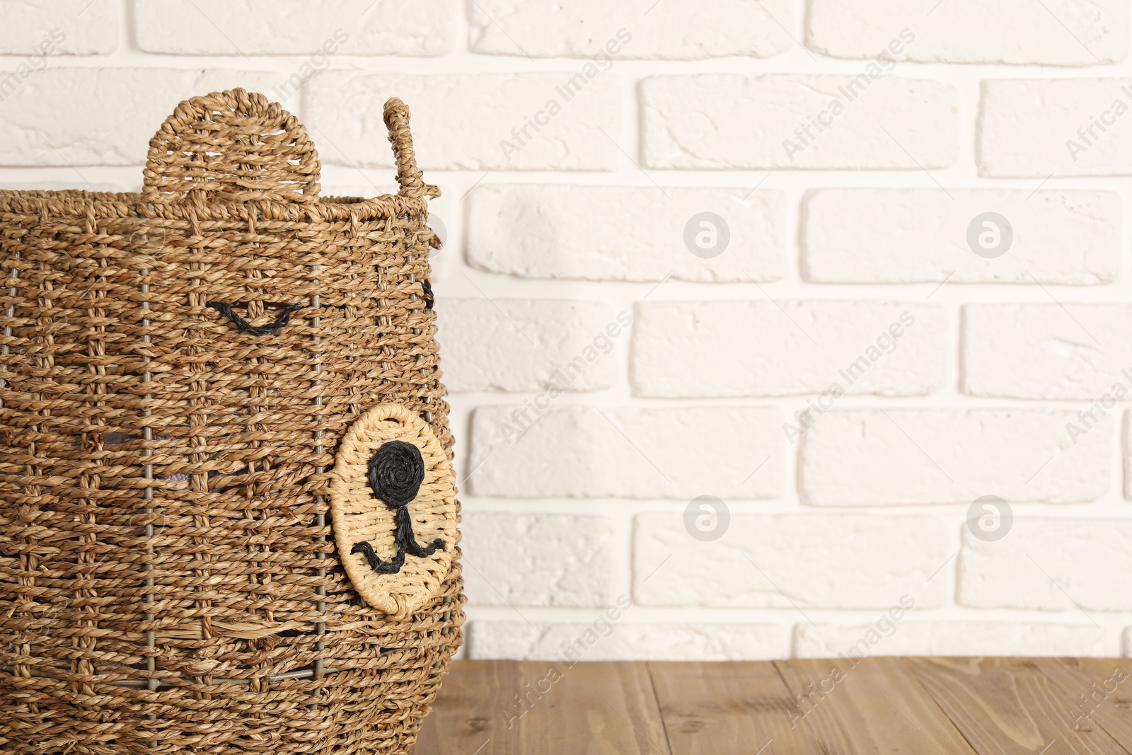 Photo of One wicker laundry basket on wooden table, space for text