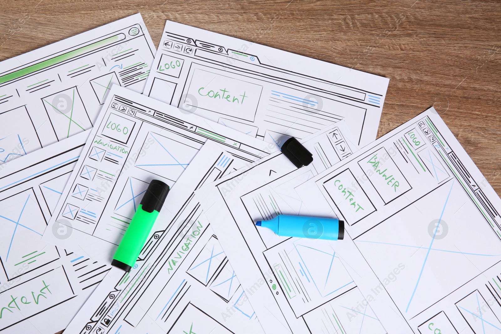 Photo of Developing UI design. Sketches of website wireframes and felt pens on wooden table, top view