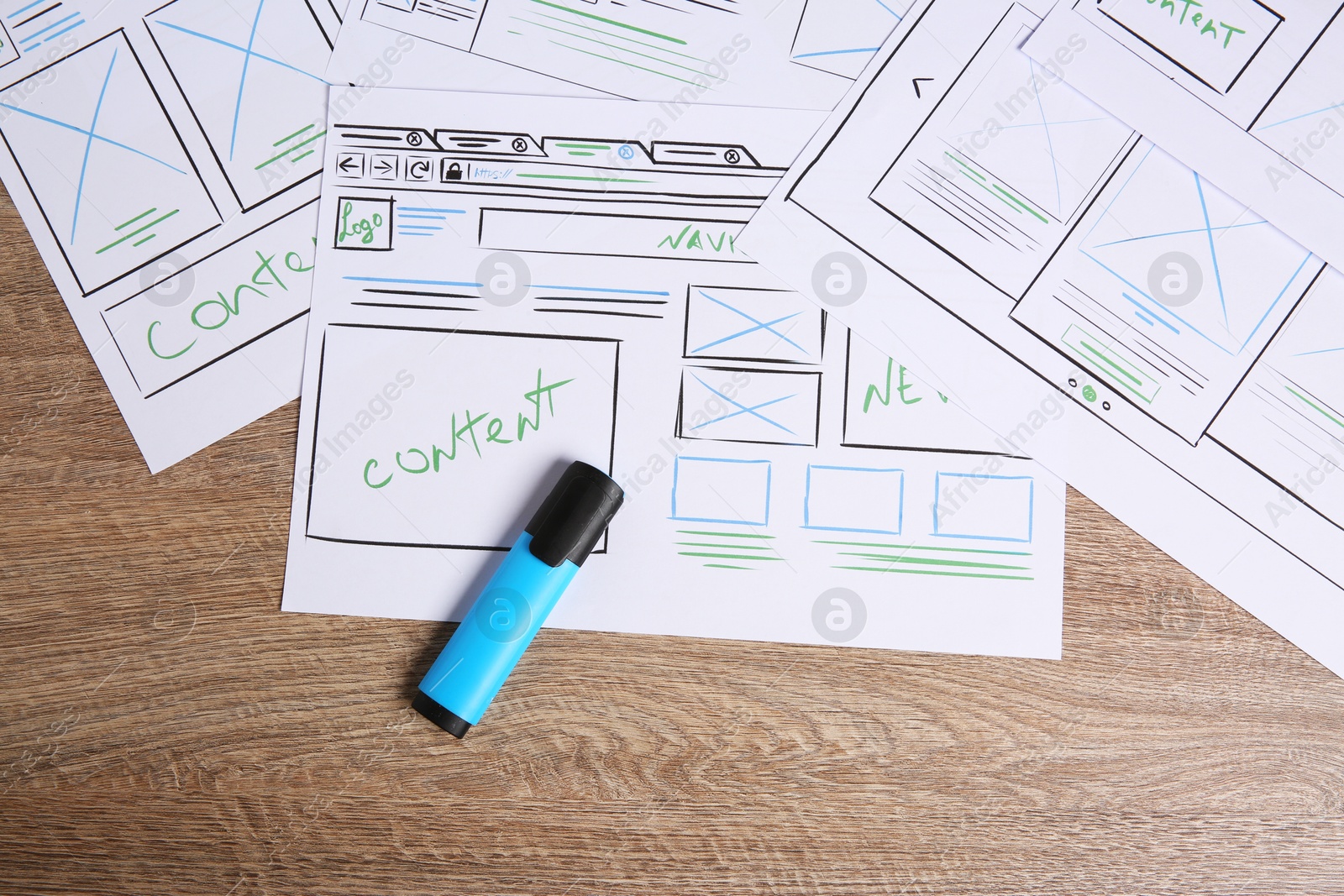 Photo of Developing UI design. Sketches of website wireframes and felt pen on wooden table, top view