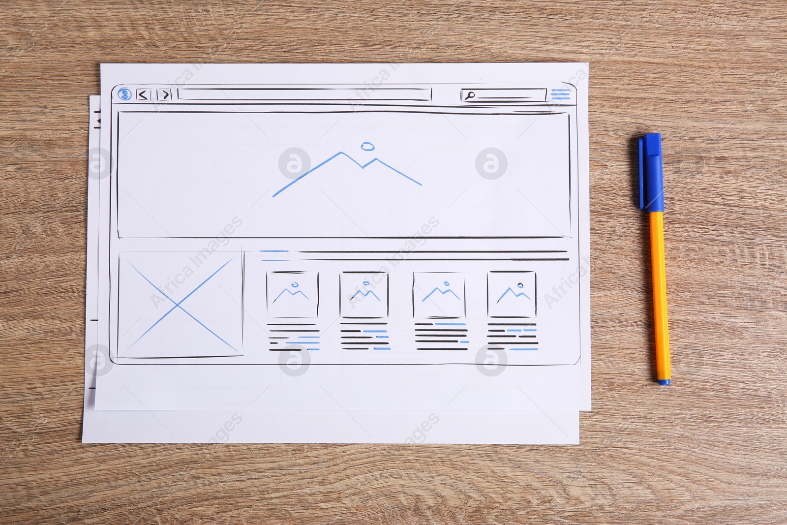 Photo of Developing UI design. Sketches of website wireframes and pen on wooden table, top view