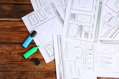 Developing UI design. Sketches of website wireframes and felt pens on wooden table, top view