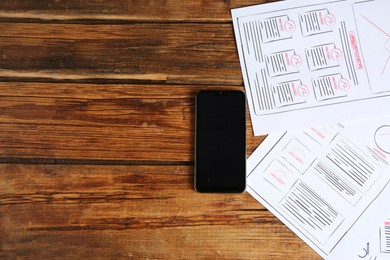 Photo of Developing UI design. Sketches of website wireframes and smartphone on wooden table, top view. Space for text