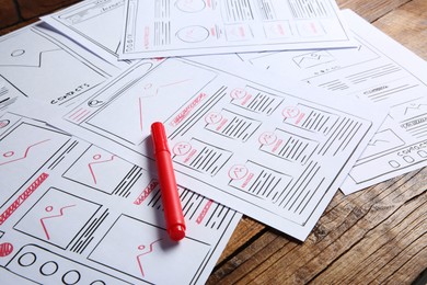 Photo of Developing UI design. Sketches of website wireframes and felt pen on wooden table, closeup