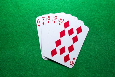 Photo of Poker game. Playing cards on green table, flat lay