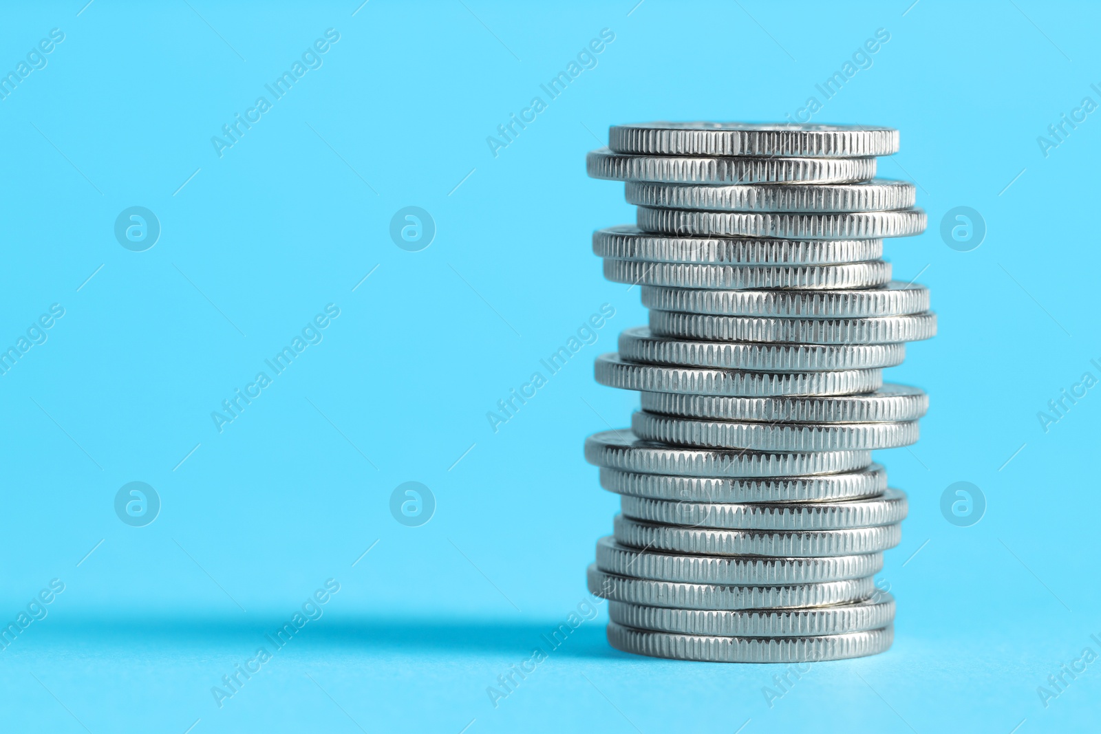 Photo of Salary concept. Stacked coins on light blue background, space for text