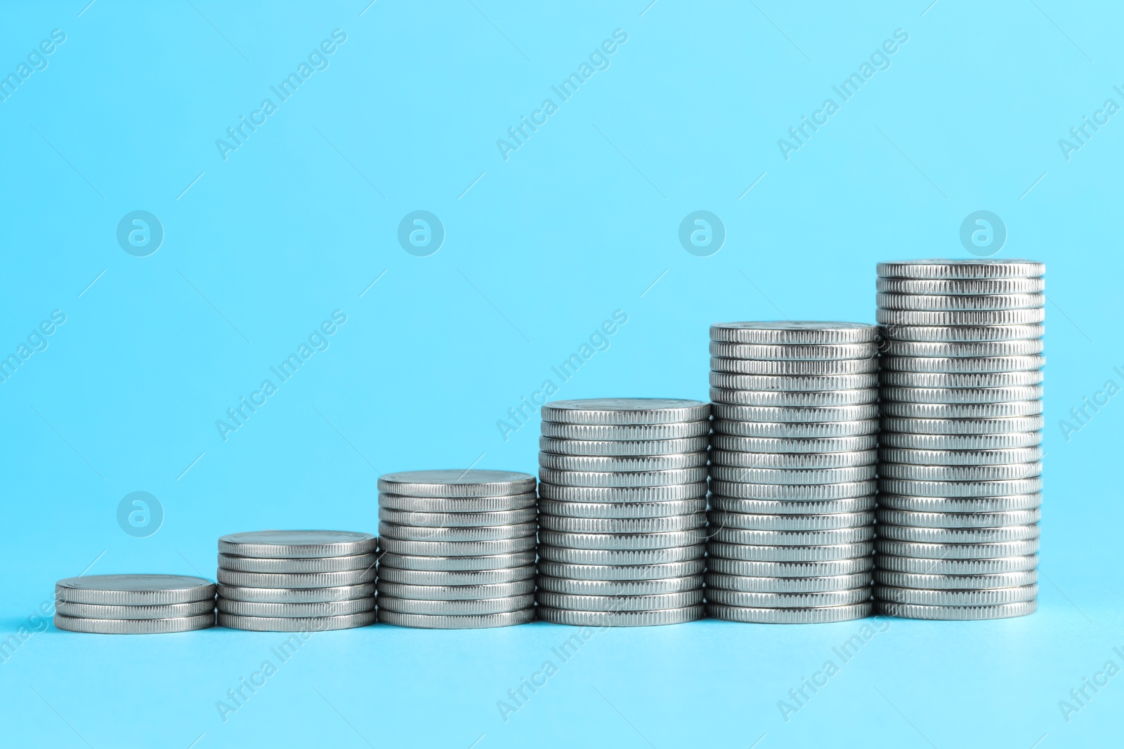 Photo of Salary concept. Stacked coins on light blue background, space for text