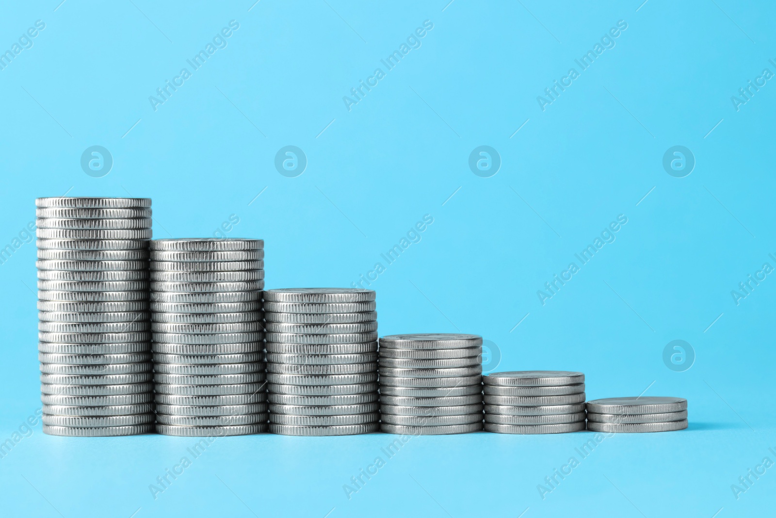 Photo of Salary concept. Stacked coins on light blue background, space for text