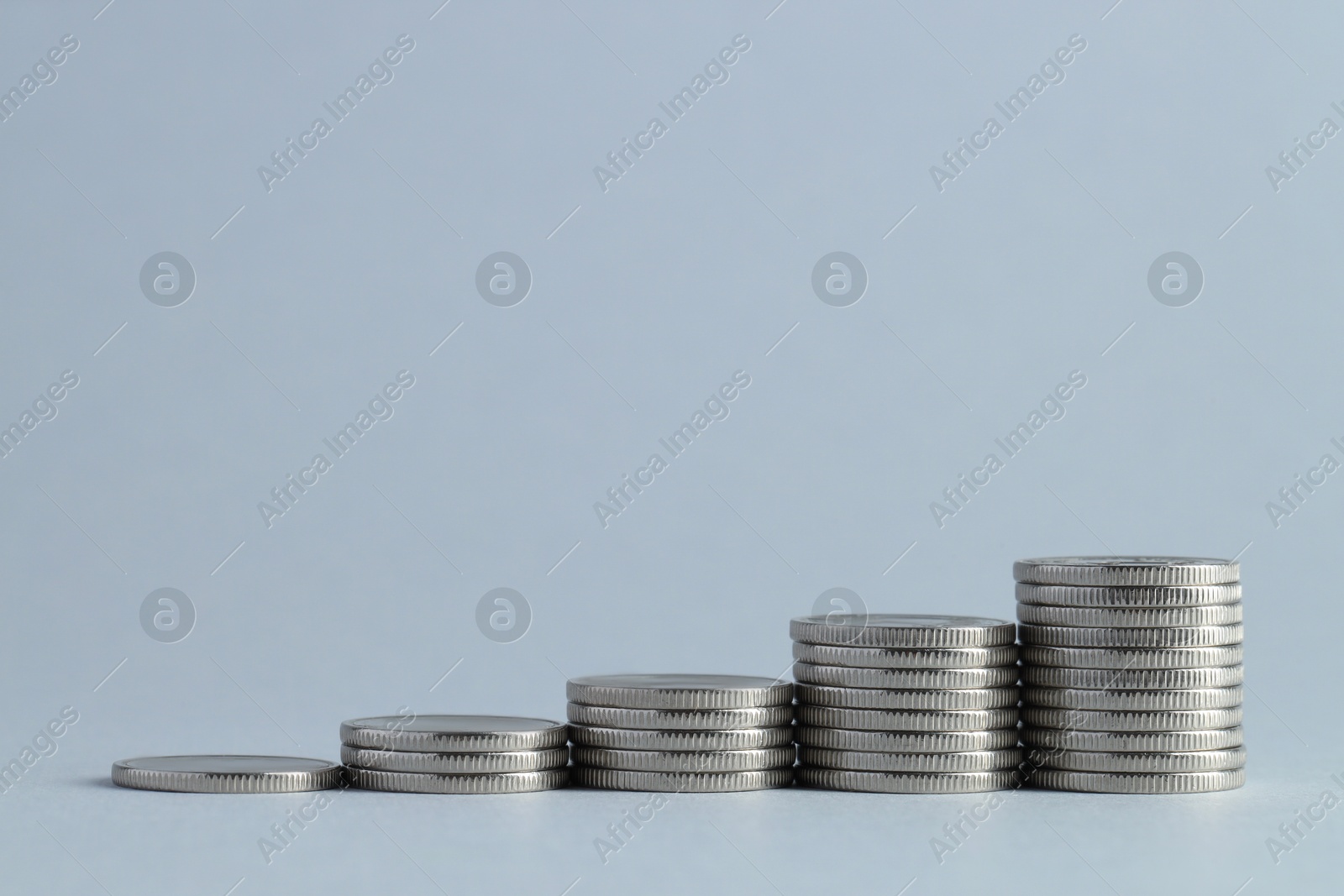 Photo of Salary concept. Stacked coins on light grey background