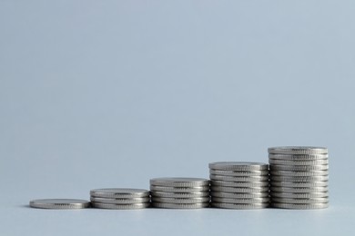 Photo of Salary concept. Stacked coins on light grey background