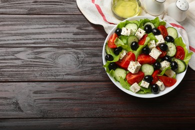 Photo of Delicious salad with feta cheese served on wooden table, top view. Space for text