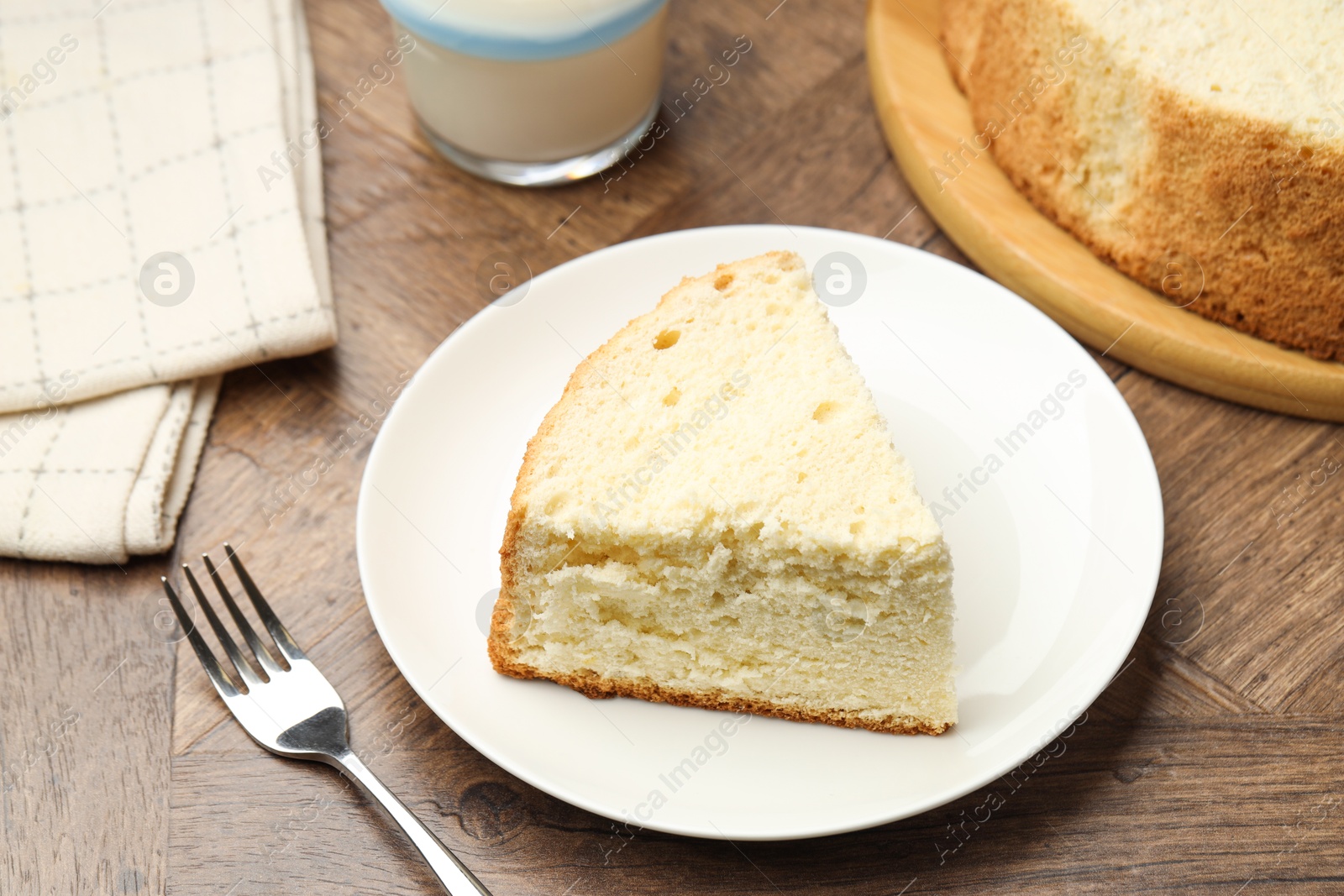 Photo of Piece of delicious sponge cake served on wooden table