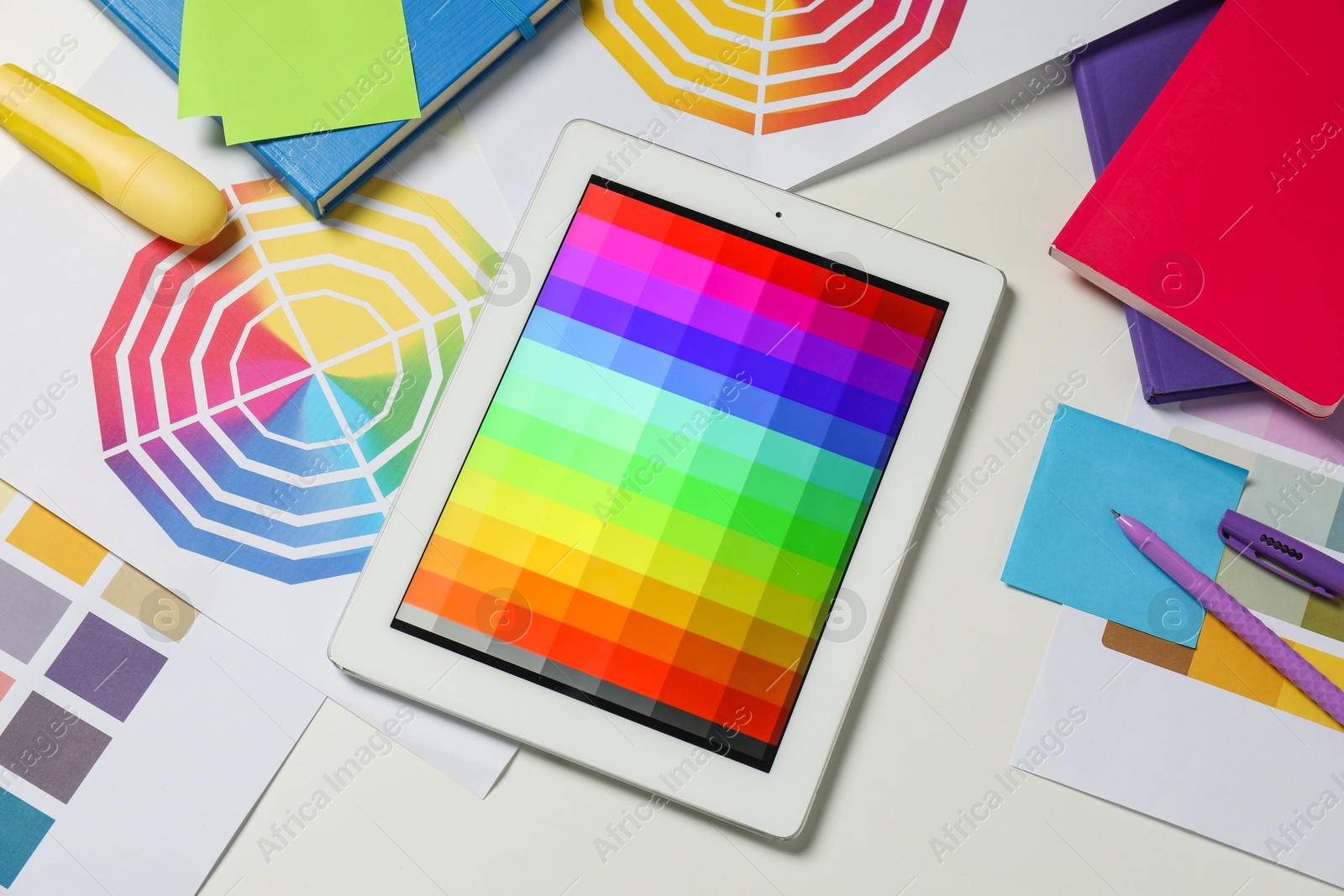 Photo of Designer's workplace with tablet, different palettes and stationery on white table, flat lay