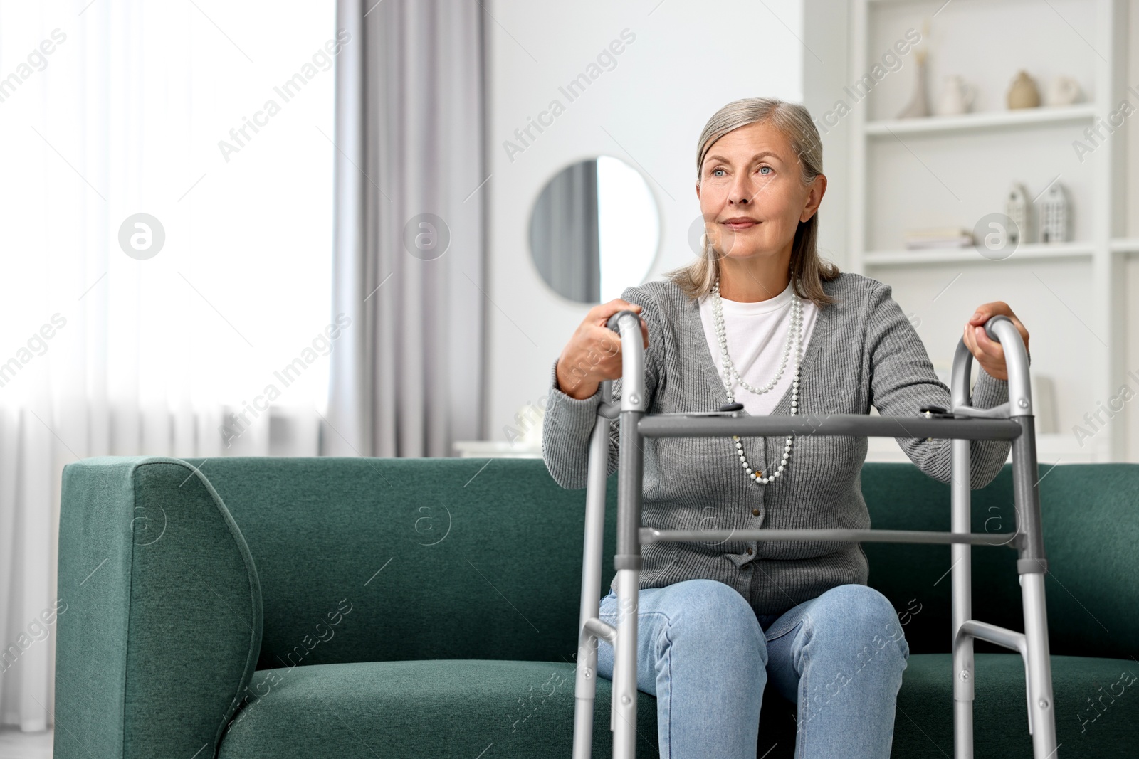 Photo of Senior woman with walking frame on sofa at home